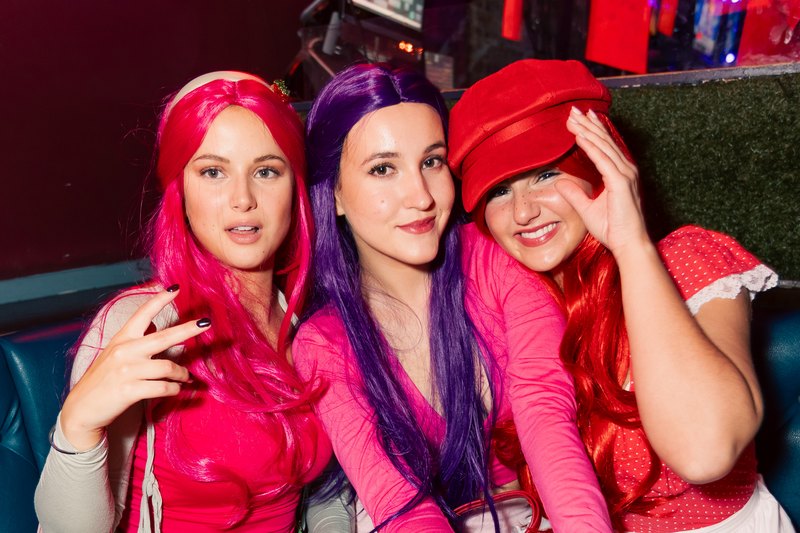 Three friends in bright wigs and costume at Crawlloween 2025